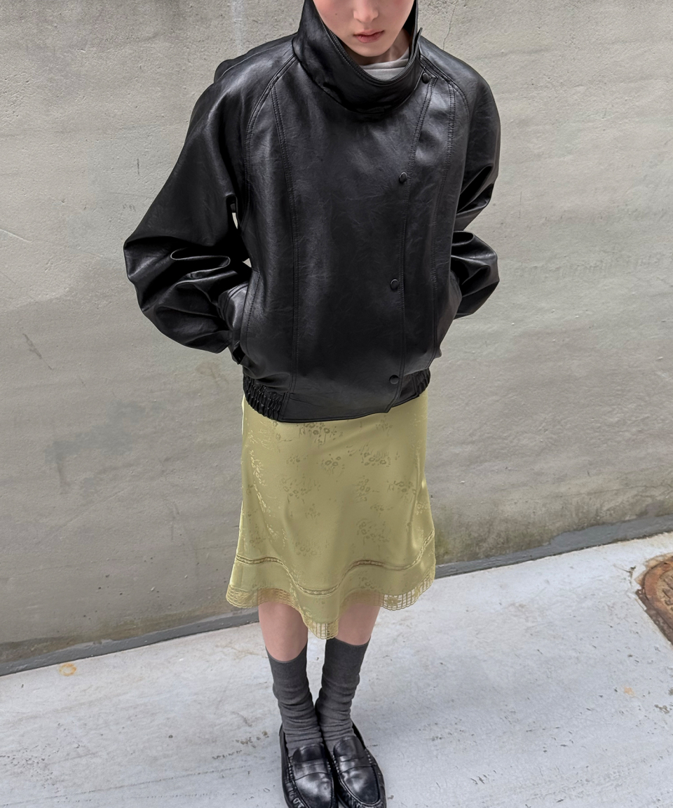 모델이 검정색 와이드 카라 인조 가죽 자켓을 입고있다.