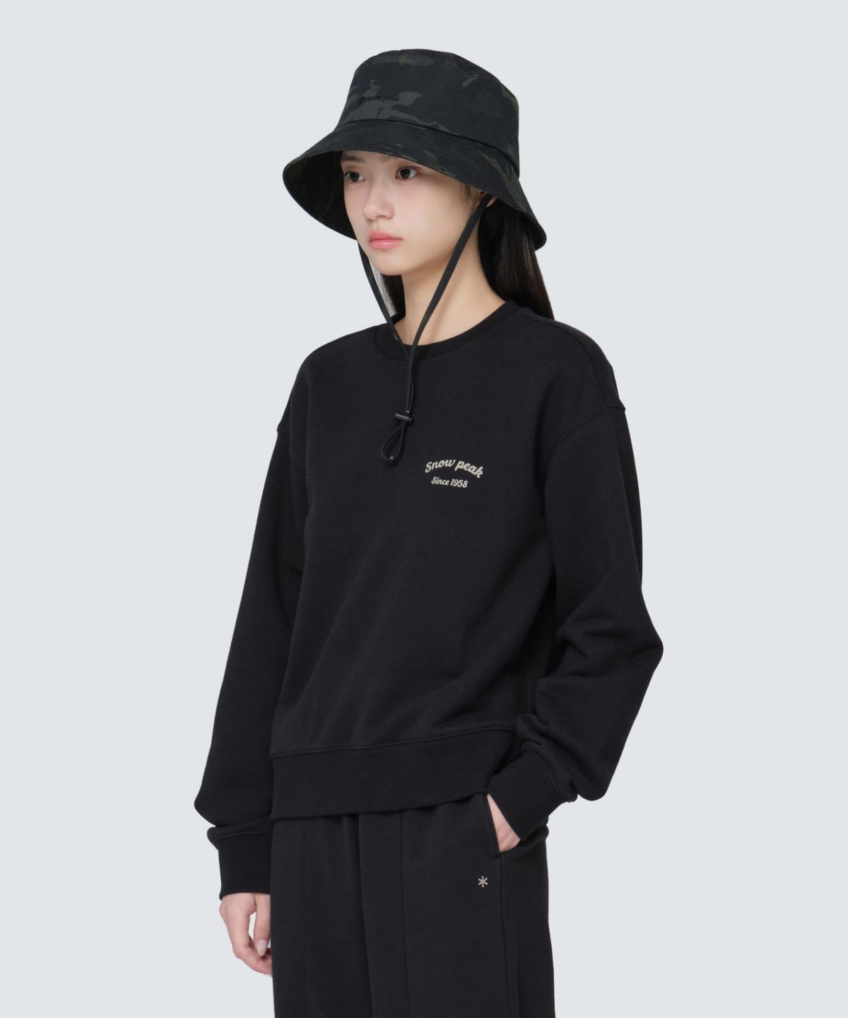 스노우피크 어패럴(SNOWPEAK APPAREL) 여성 레터링 세미 크롭 맨투맨 (S24FWFHT63) Black