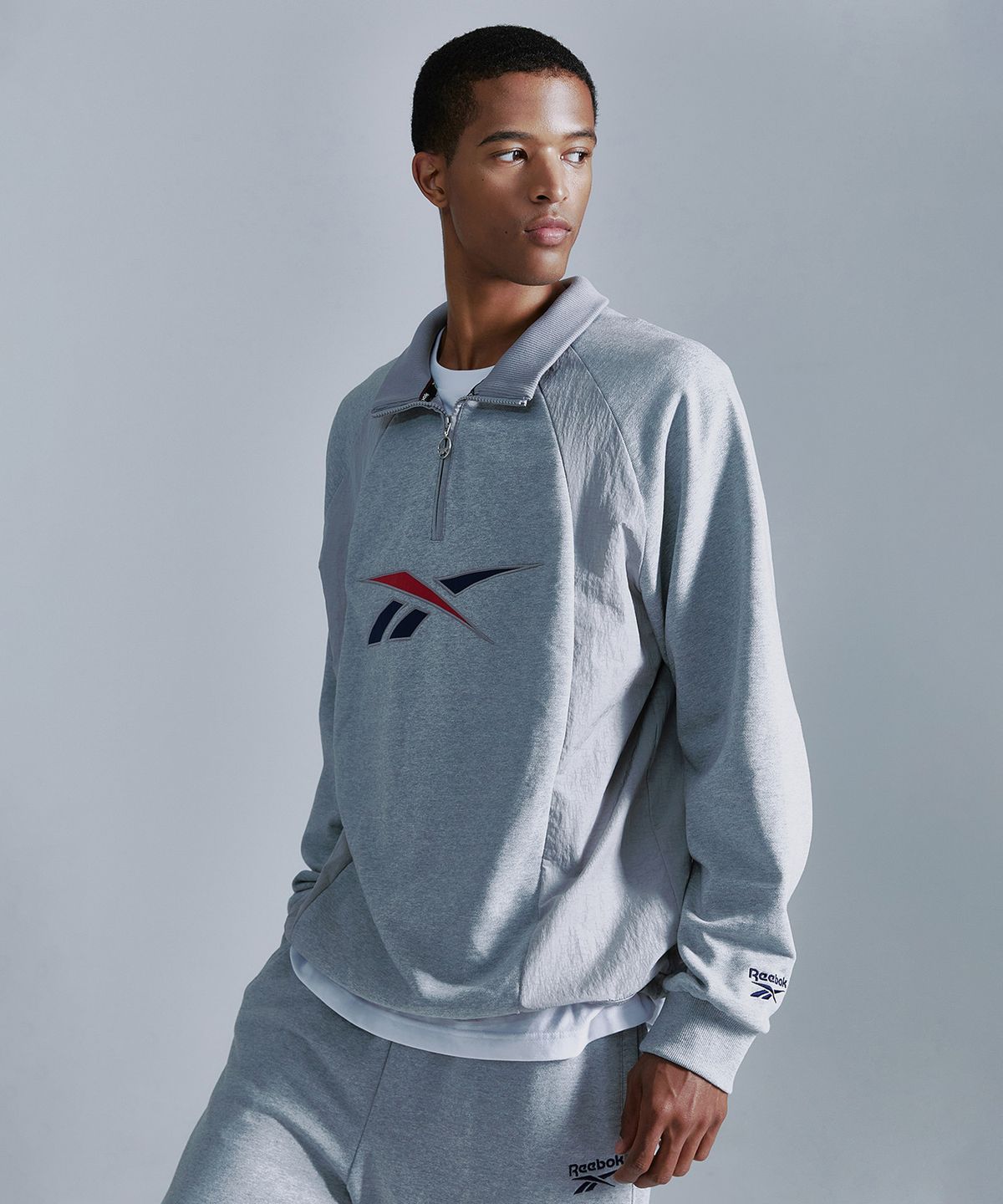 리복(REEBOK) 뉴벡터 하이브리드 하프 집업 - 그레이