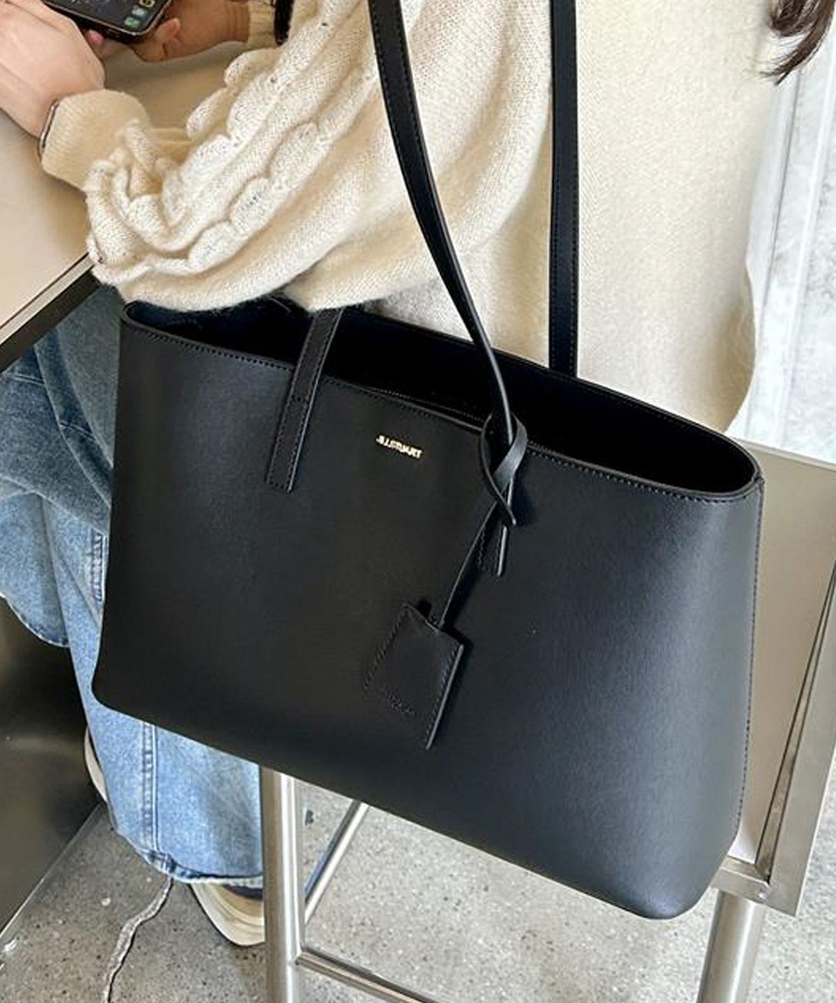 질스튜어트액세서리(JILLSTUART ACC) [시티에센셜] 로고 장식 블랙 비건레더 숄더백 (노트북수납가능)
