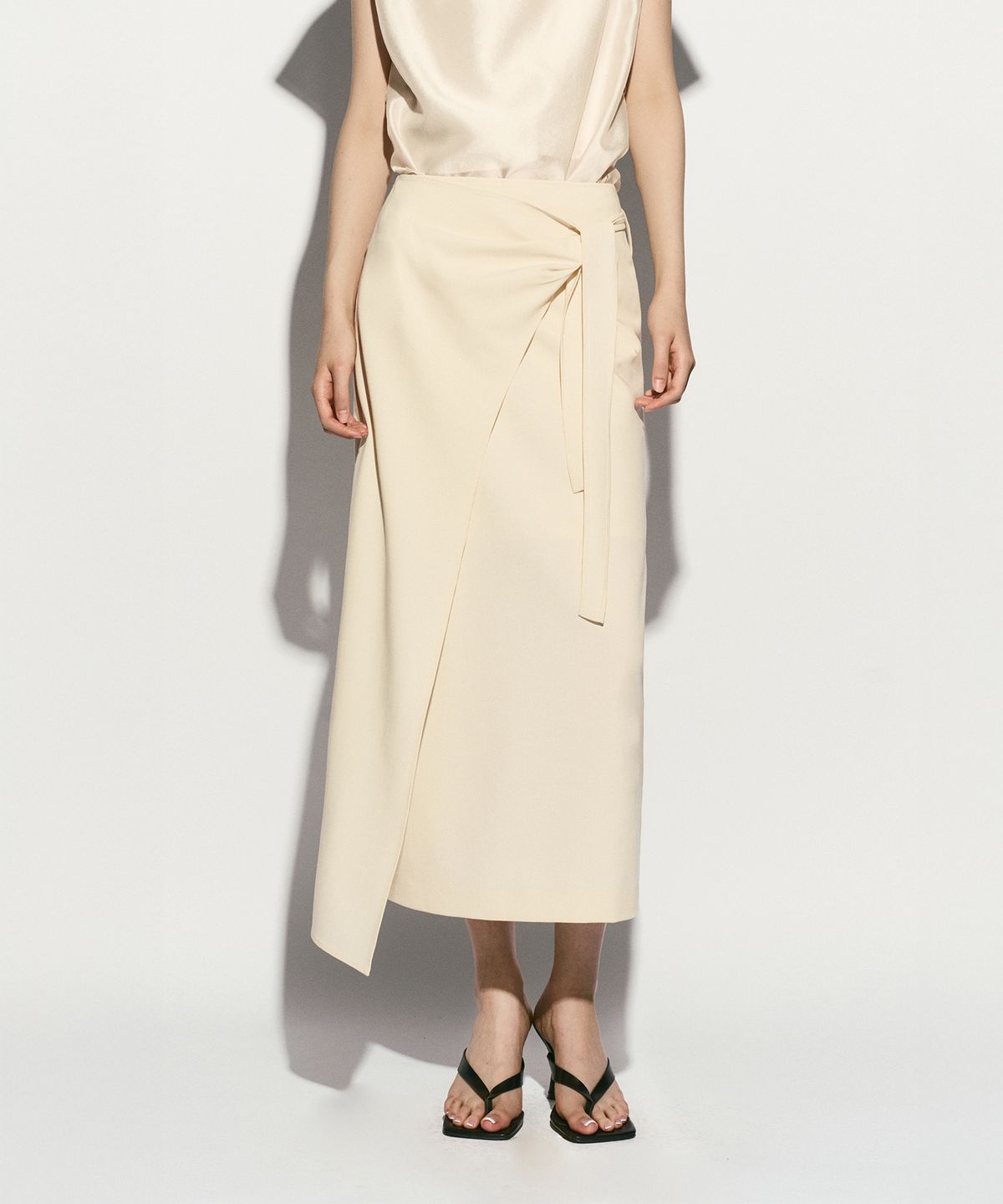 리이(RE RHEE) ASYMMETRIC HEM SIDE TIE SKIRT
