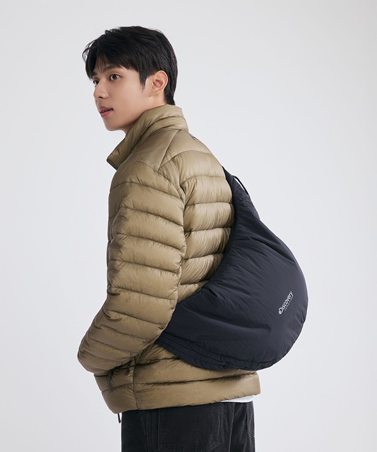 디스커버리 익스페디션(DISCOVERY EXPEDITION) 커브 패디드 드로스트링 퍼커링 백 L (BLACK)