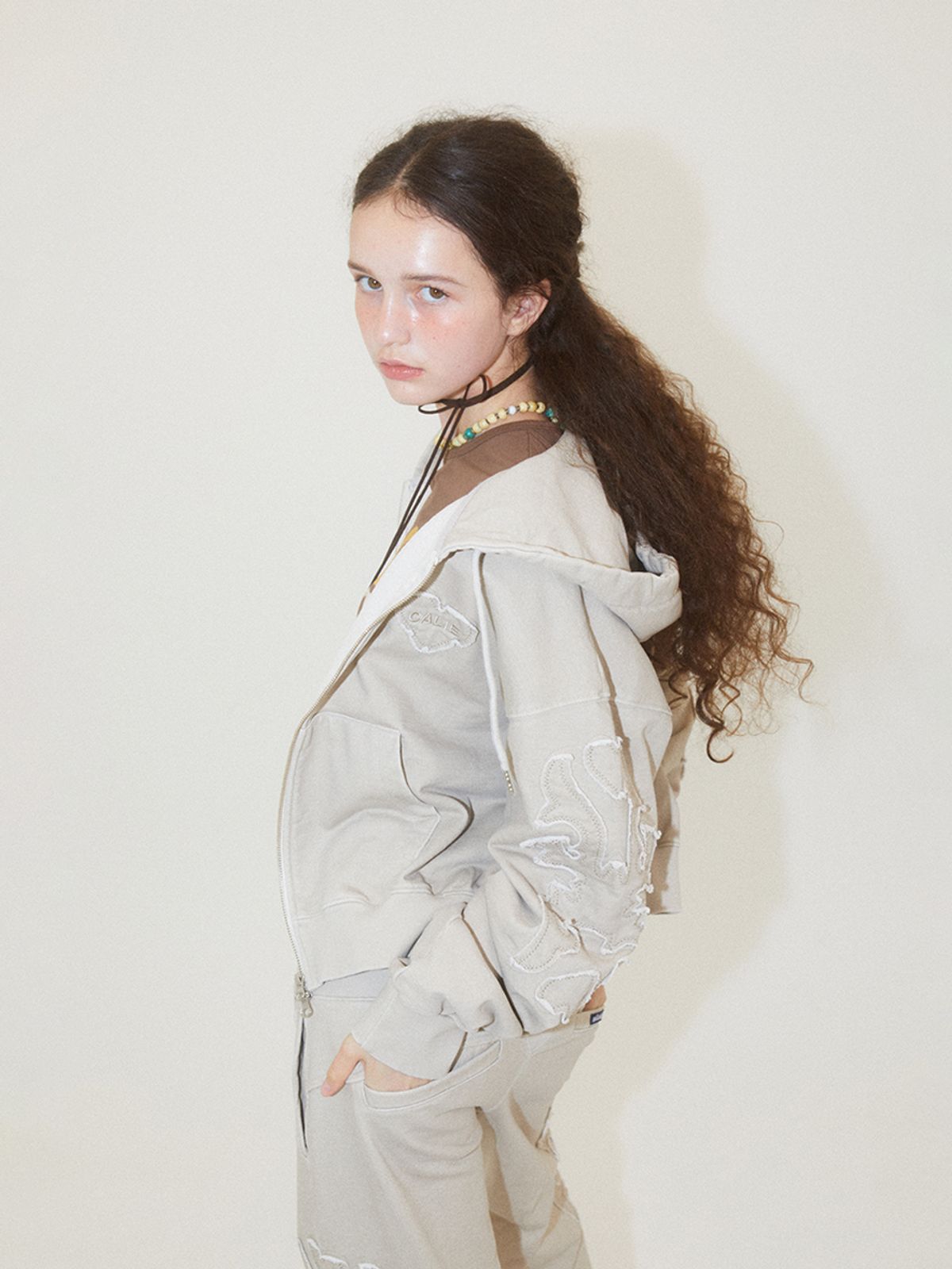 에즈이프 캘리(ASIF CALIE) APPLIQUE 2WAY HOOD ZIP-UP IVORY