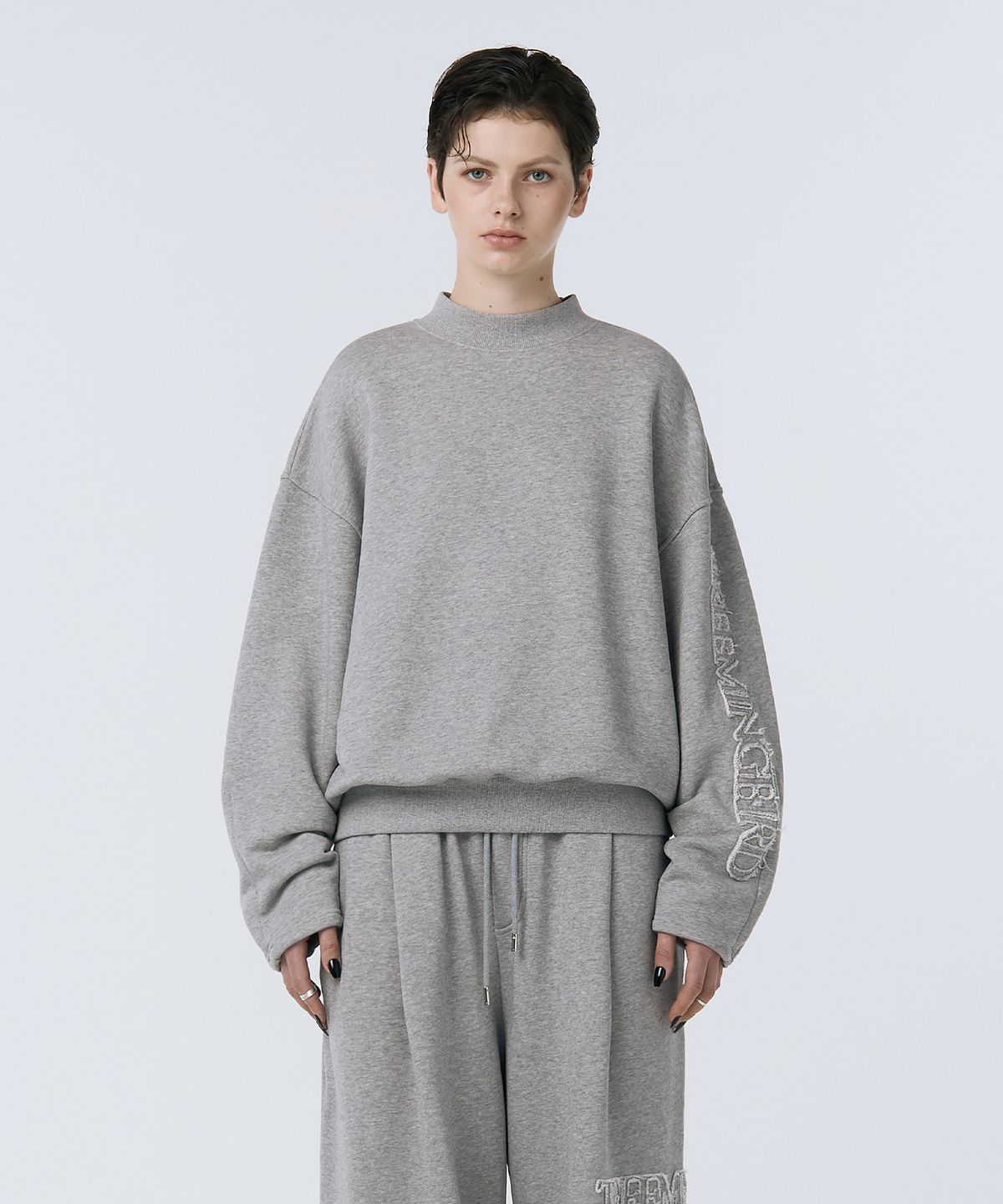 트리밍버드(TREEMINGBIRD) Cut-out Patch Mock Neck Sweatshirt [ Melange Gray ]
