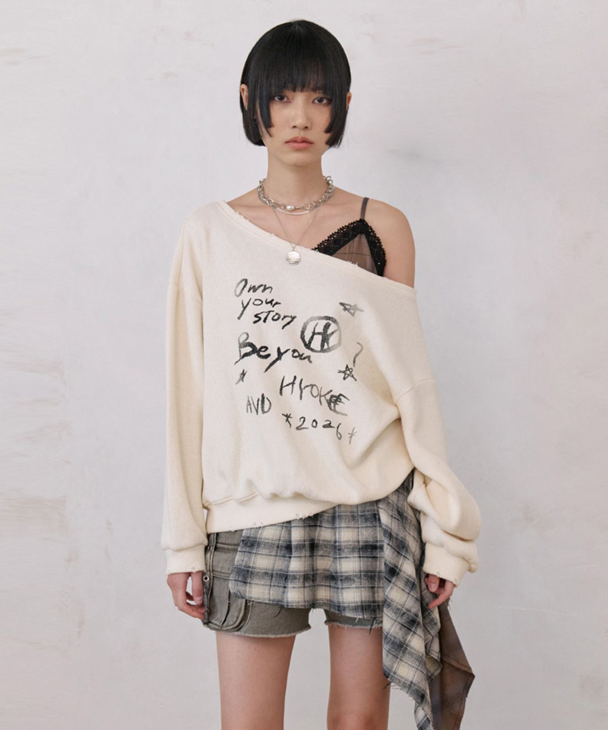 노 엑스트라 터치(NO EXTRA TOUCH) One-shoulder graphic sweatshirt (cream)_26SPSS001CR