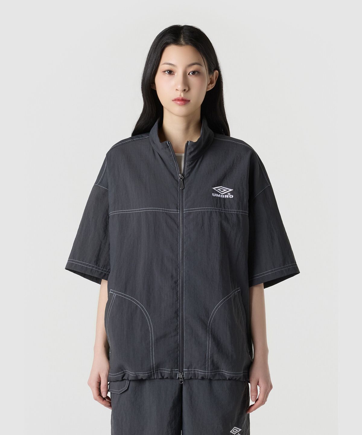 엄브로(UMBRO) 크리스피 타슬란 스탠넥 반팔 풀집 자켓 차콜 UR221CJK57