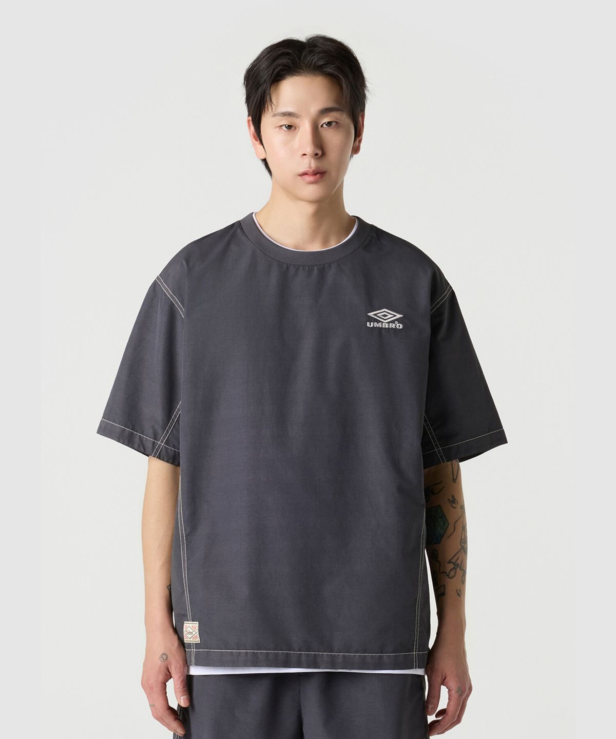 엄브로(UMBRO) 콘크리트 블룸 다잉 우븐 반팔 피스테 차콜 UR221CWT55