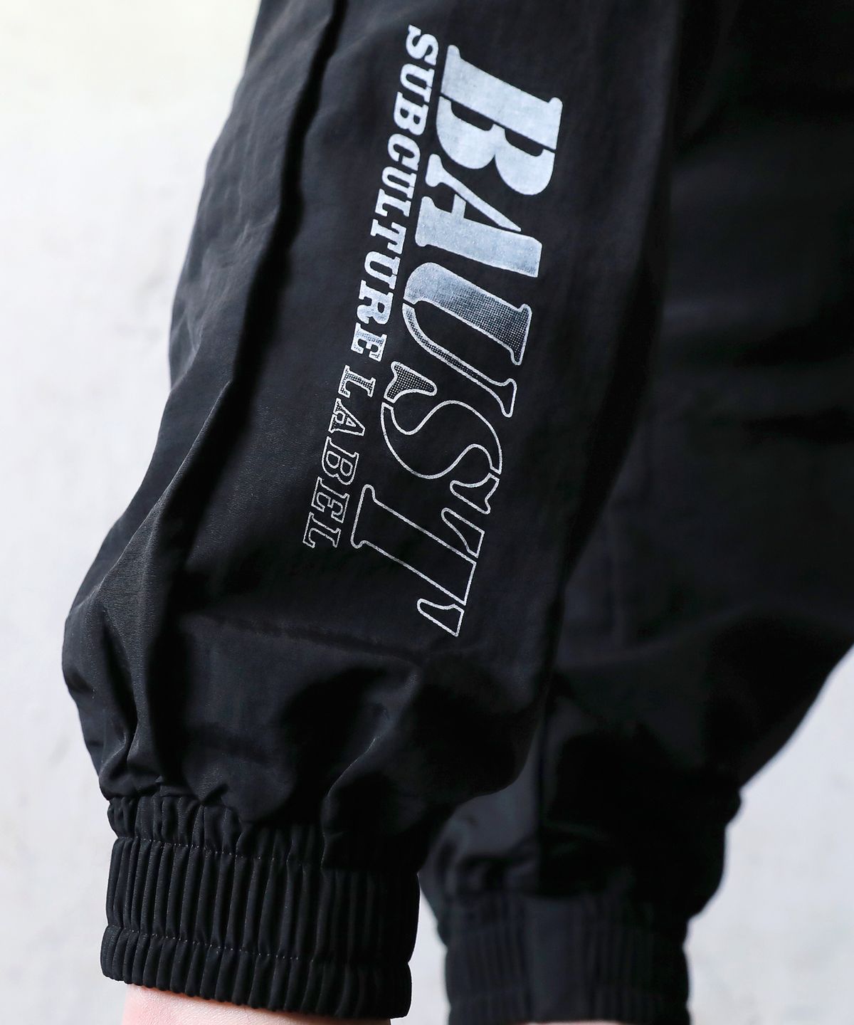 바우스트(BAUST) 그라데이션 로고 지퍼 더블 카고포켓 조거팬츠[BLACK]