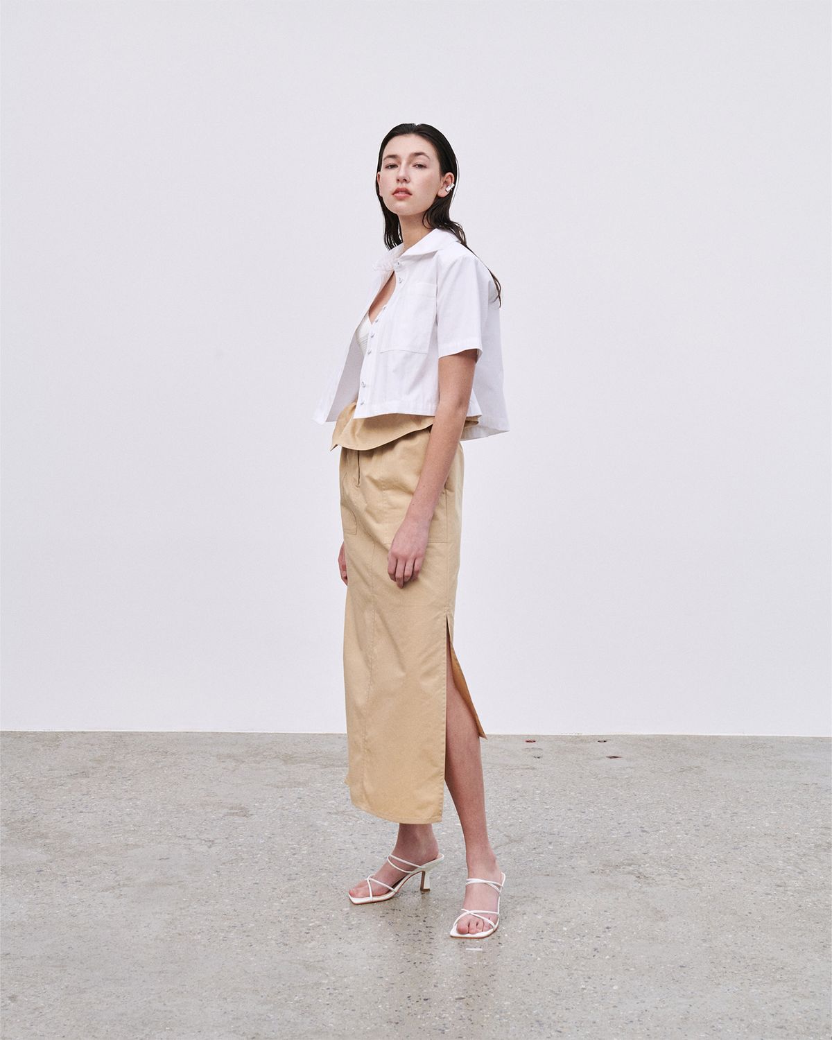 언뮤트(UNMUTE) CURVED DRAPERY MIDI SKIRT (CARAMEL)