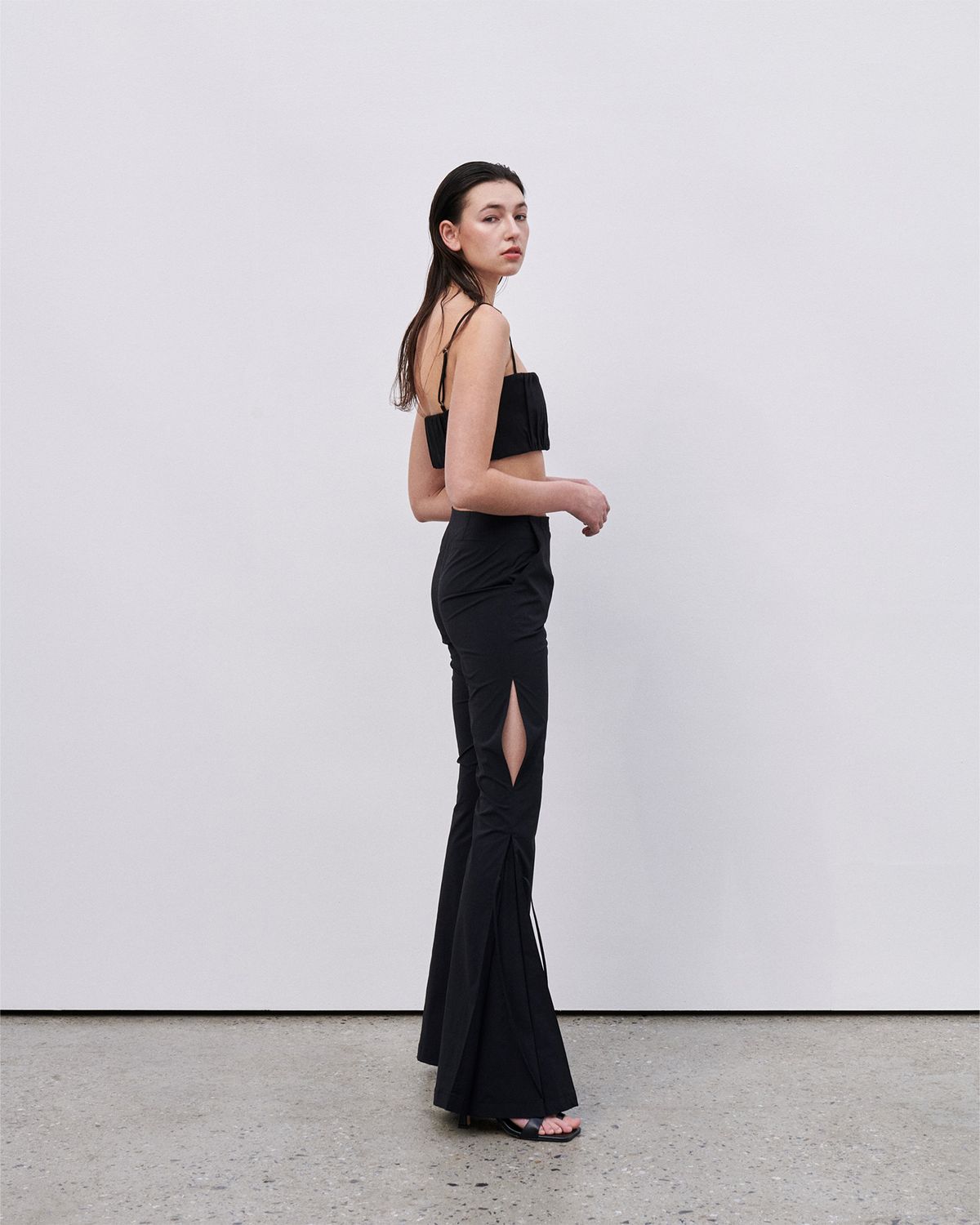 언뮤트(UNMUTE) SLIT DETAIL FLARED PANTS (BLACK)