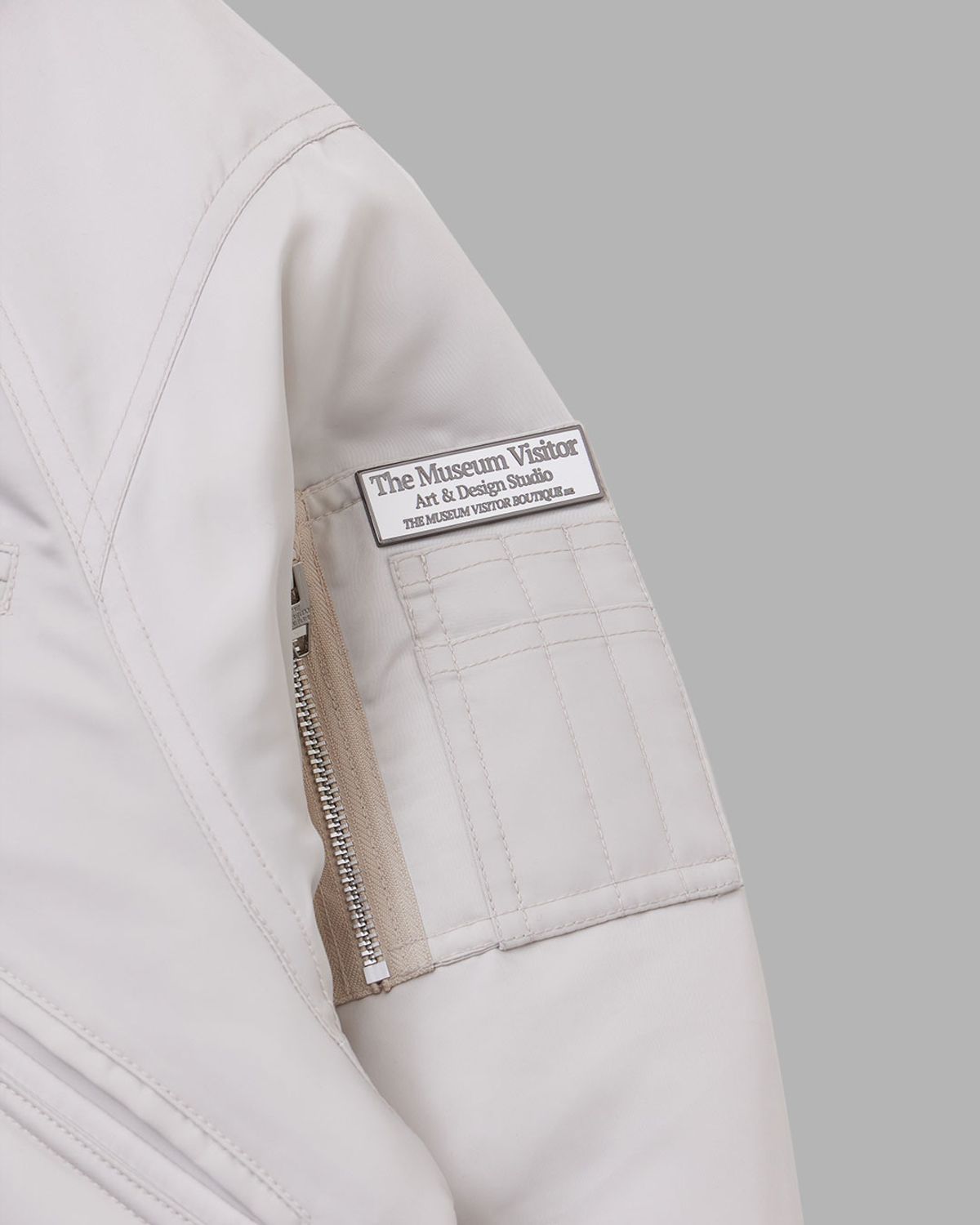 더뮤지엄비지터(THEMUSEUMVISITOR) FUR HOOD METAL LOGO MA-1 JUMPER (IVORY)