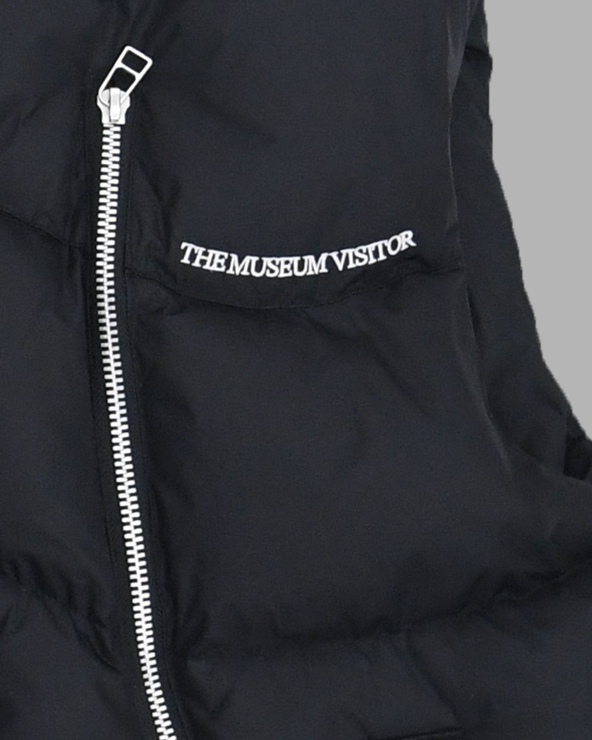더뮤지엄비지터(THEMUSEUMVISITOR) CURVED ZIPPER PUFFER DOWN VEST (BLACK)