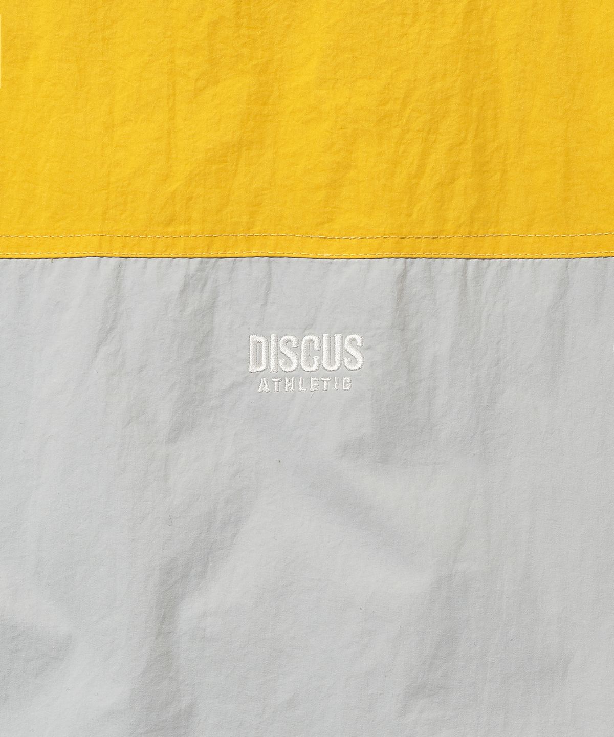디스커스 애슬레틱(DISCUS ATHLETIC) 로고 배색 윈드브레이커 옐로우