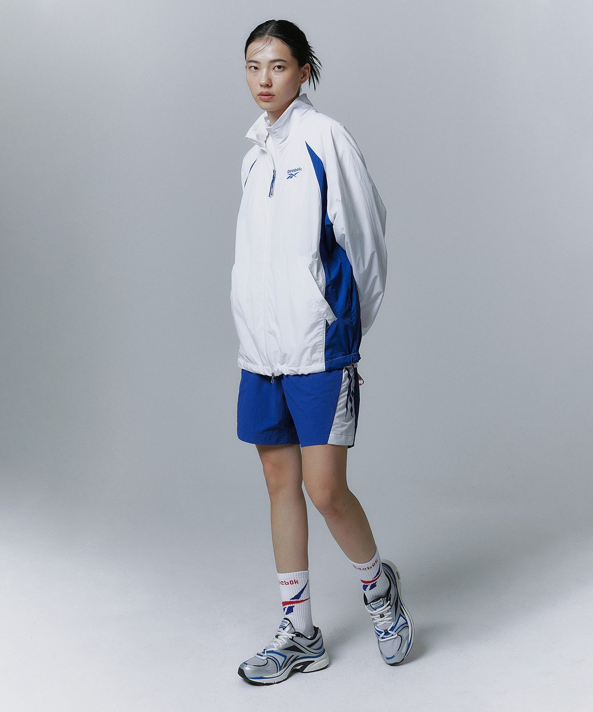 리복(REEBOK) 에센셜 써클 경량 윈드 브레이커 - 화이트:블루