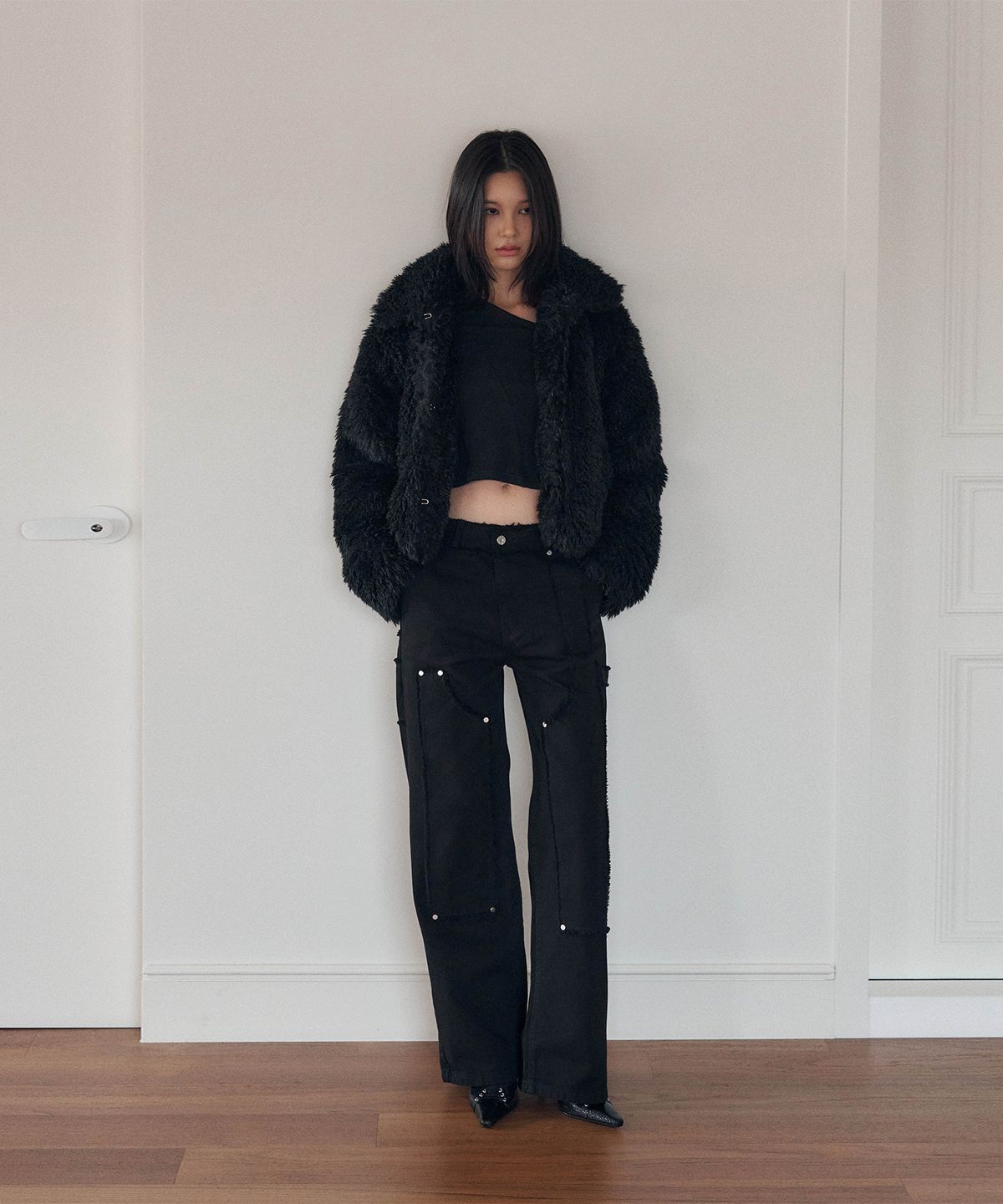 Woman wearing black cargo pants with a faux fur coat