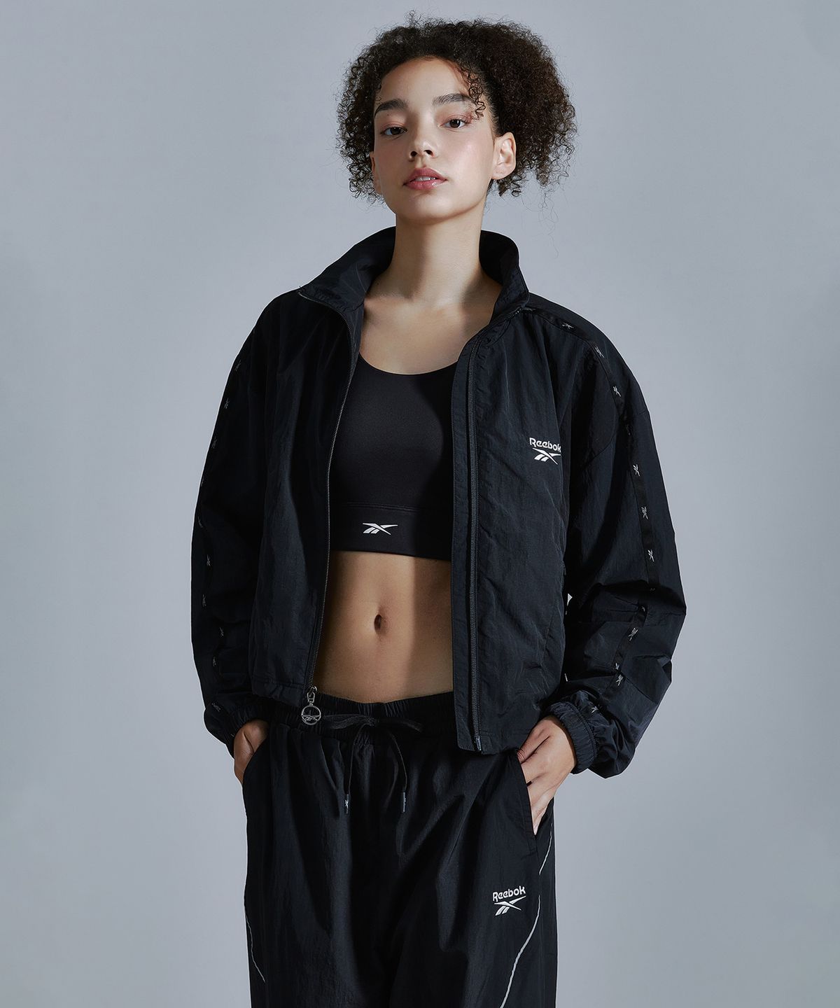 리복(REEBOK) 라이벌 크롭 윈드 브레이커 (W) - 블랙