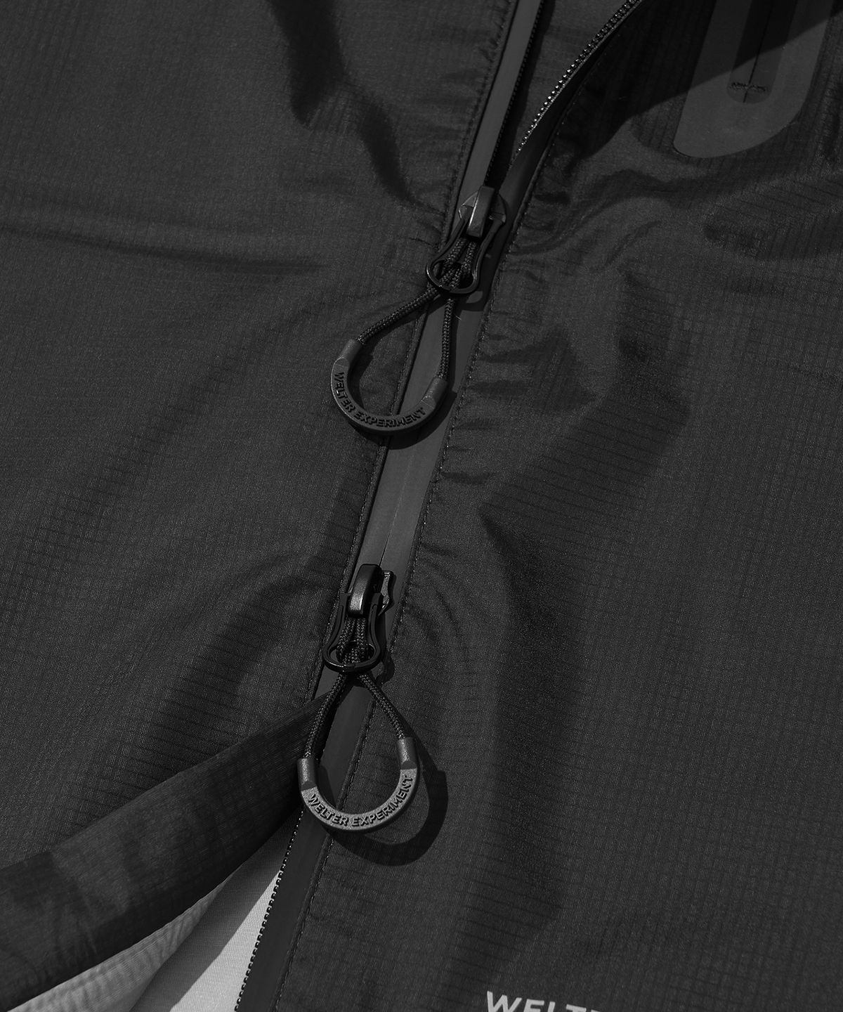 웰터 익스페리먼트(WELTER EXPERIMENT) 3LAYER SLIT REFLECTIVE HARD SHELL JACKET_BLACK_WOL063