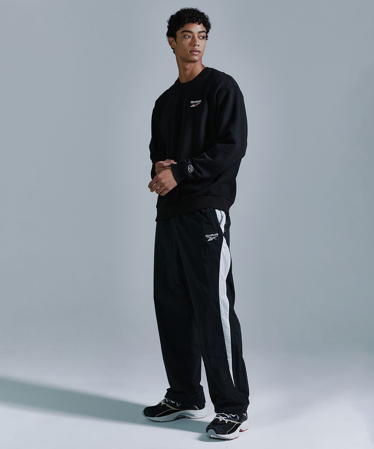 리복(REEBOK) 레터링 기모 맨투맨 - 블랙