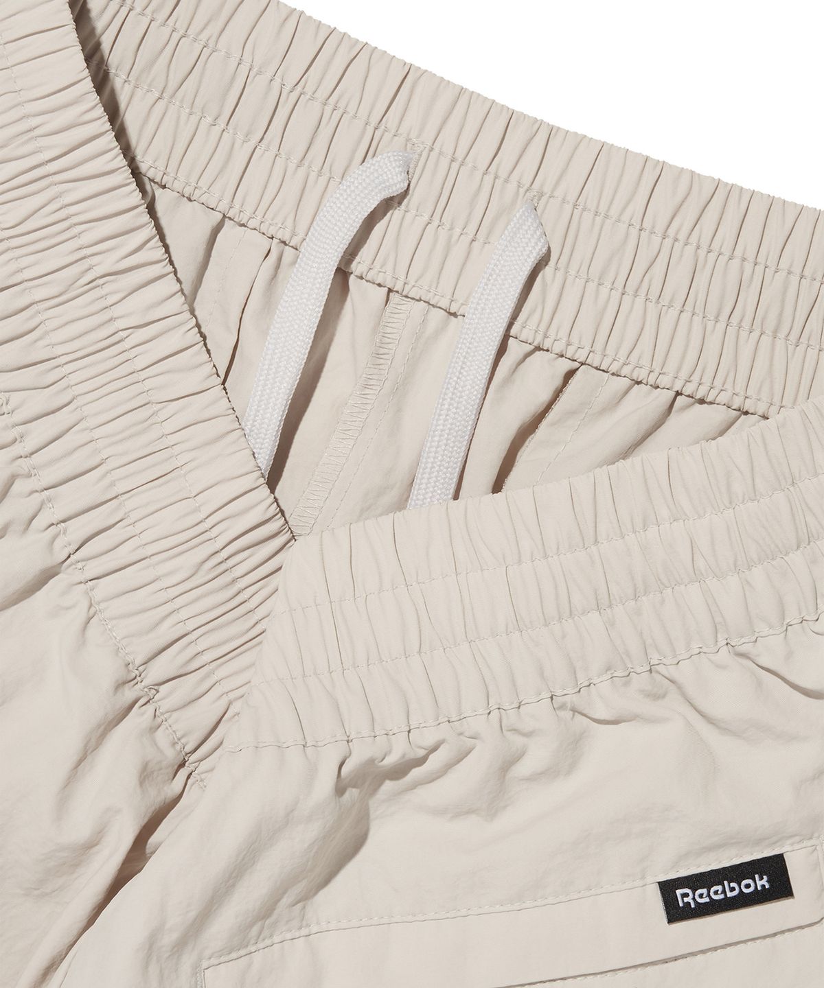 리복(REEBOK) 에센셜 웜업 팬츠 - 베이지