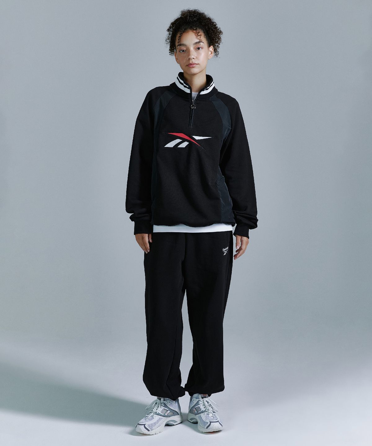 리복(REEBOK) 뉴벡터 하이브리드 하프 집업 - 블랙