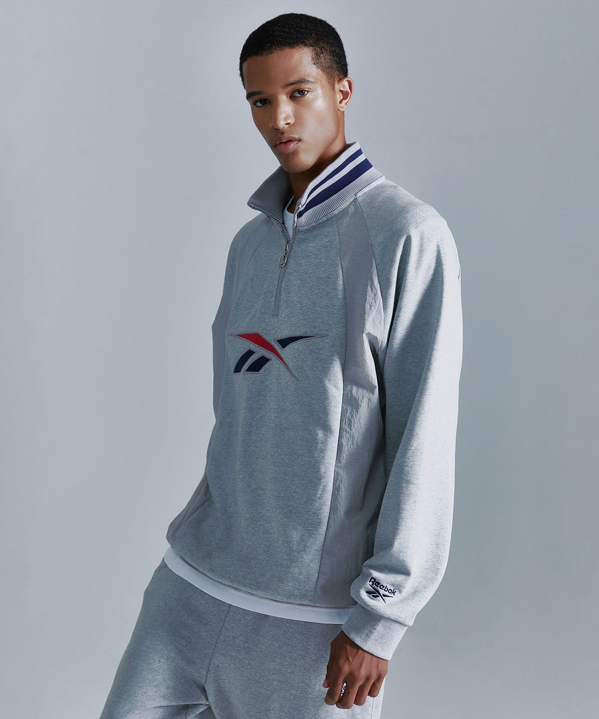 리복(REEBOK) 뉴벡터 하이브리드 하프 집업 - 그레이