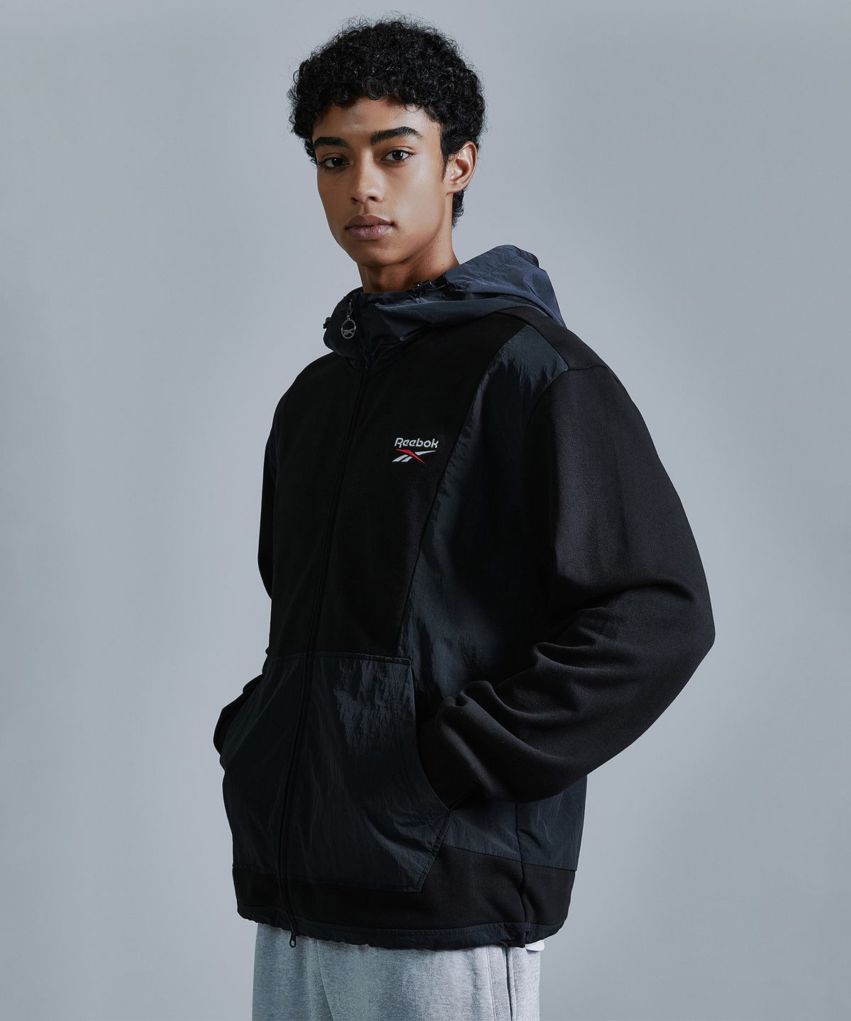 리복(REEBOK) 뉴벡터 하이브리드 후드집업 - 블랙