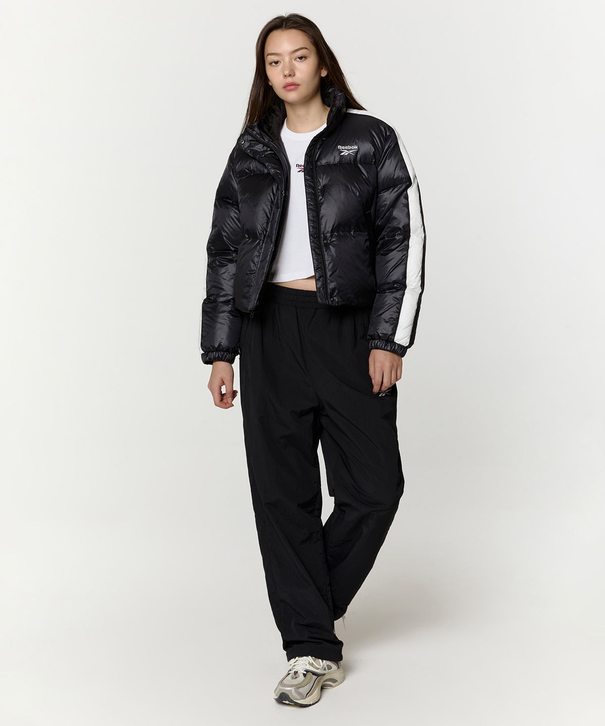 리복(REEBOK) 글로시 패널드 크롭 다운 자켓 (W) - 블랙