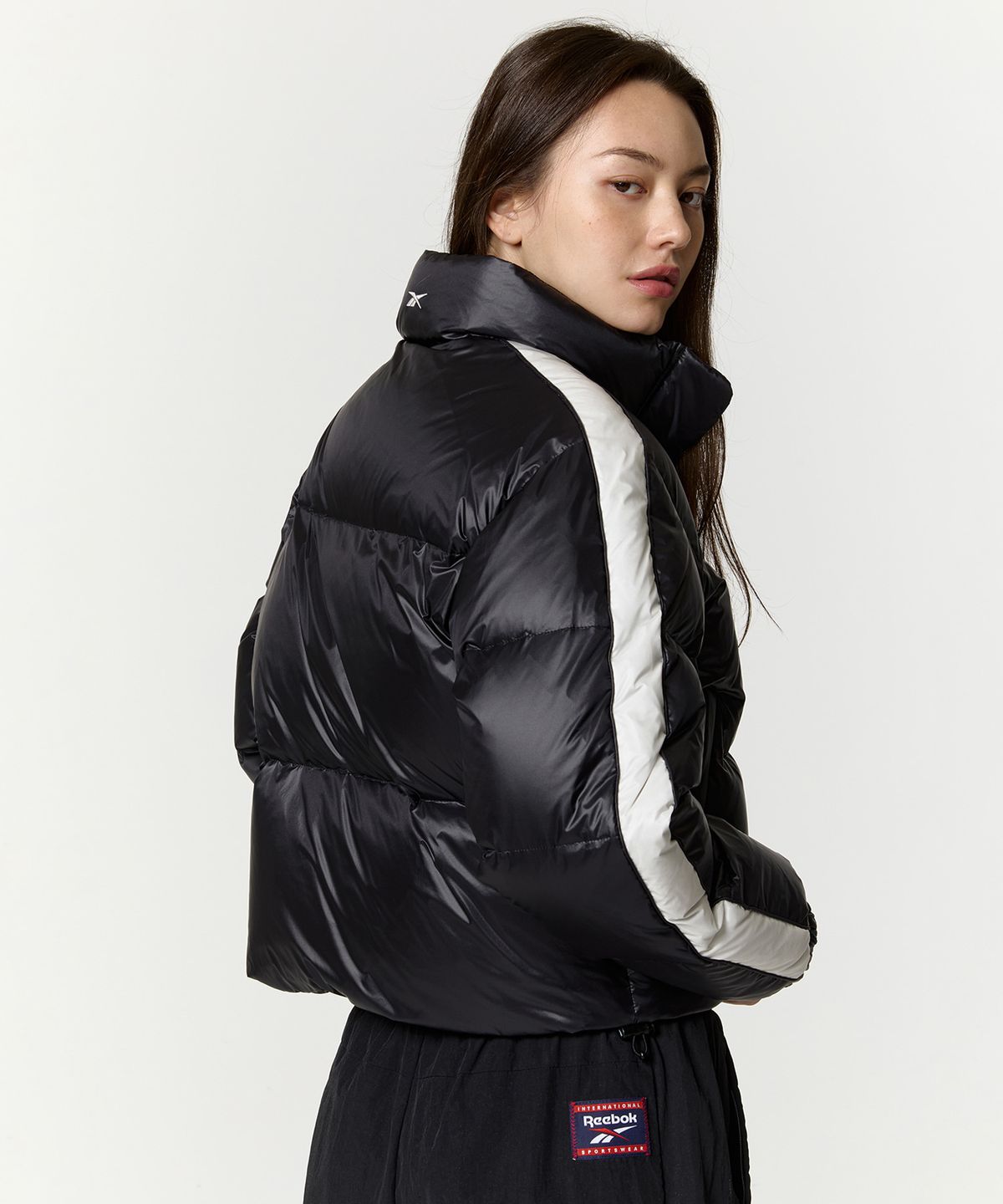 리복(REEBOK) 글로시 패널드 크롭 다운 자켓 (W) - 블랙