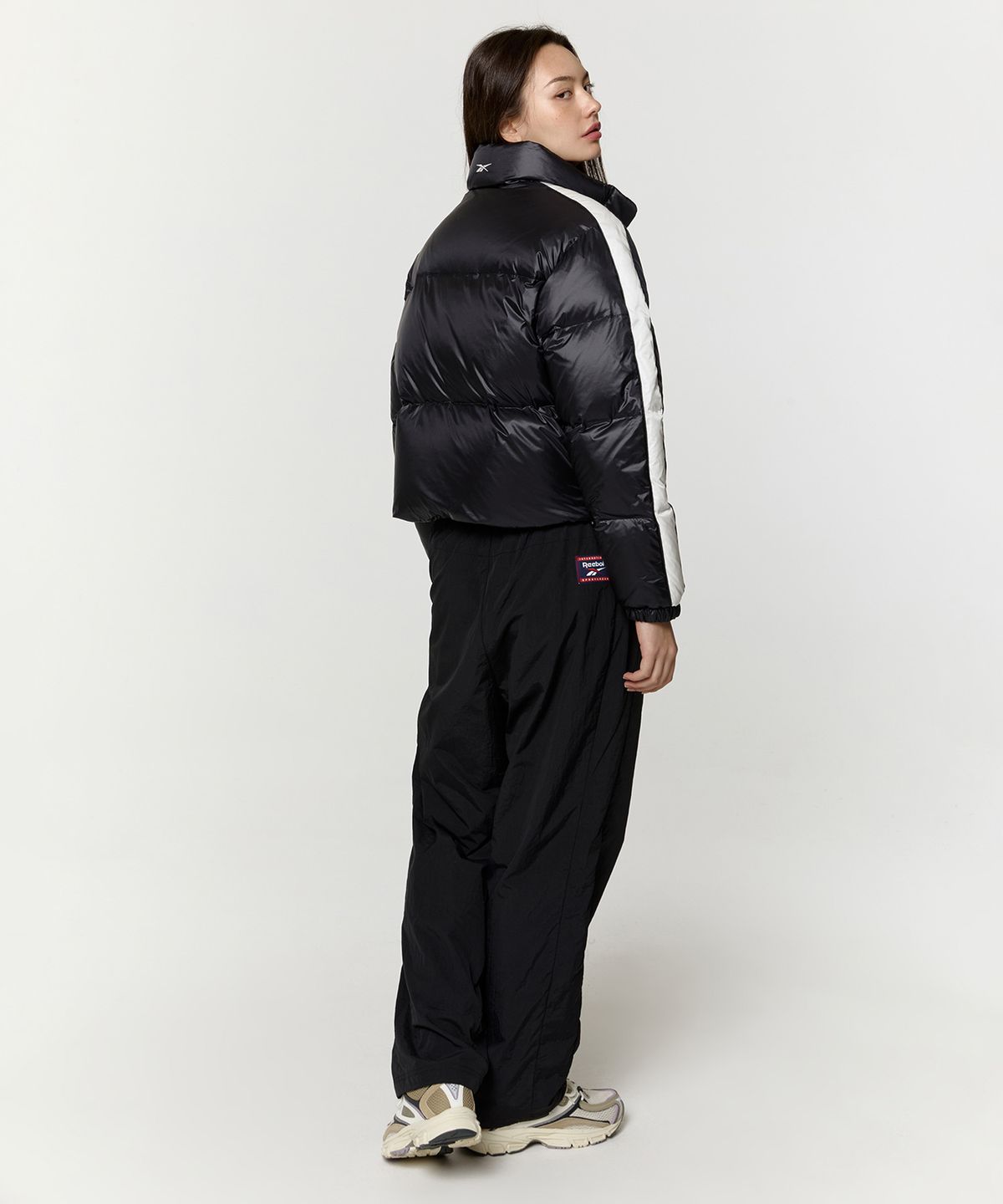 리복(REEBOK) 글로시 패널드 크롭 다운 자켓 (W) - 블랙