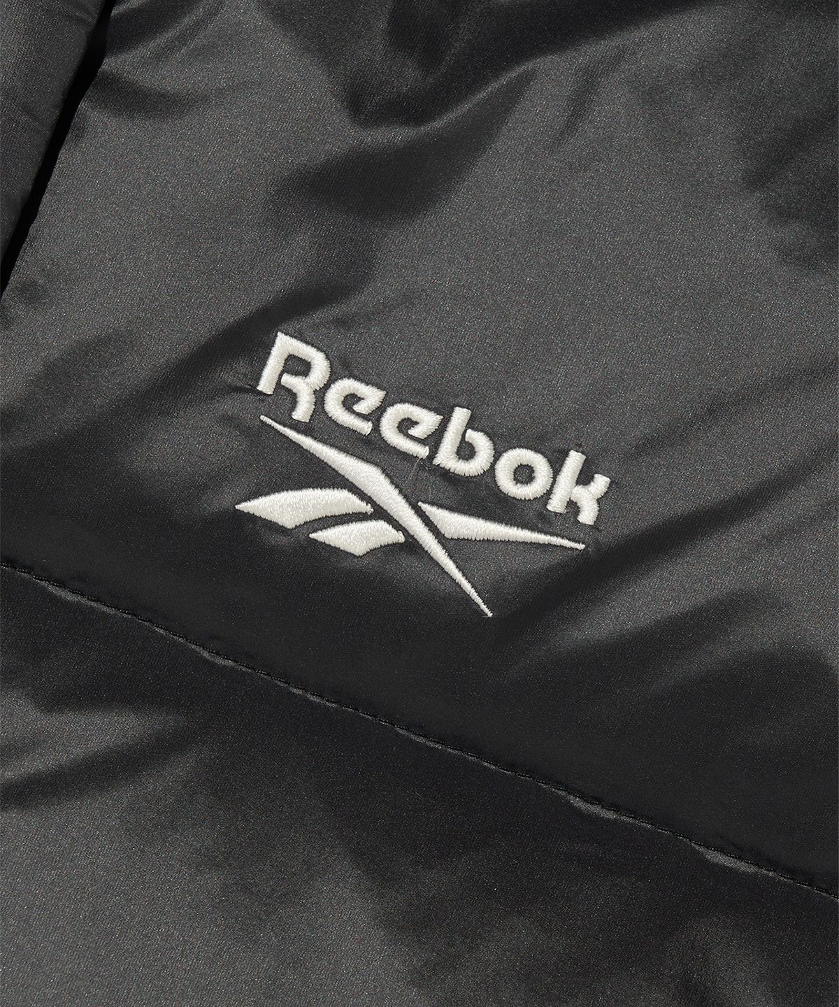 리복(REEBOK) 글로시 패널드 크롭 다운 자켓 (W) - 블랙