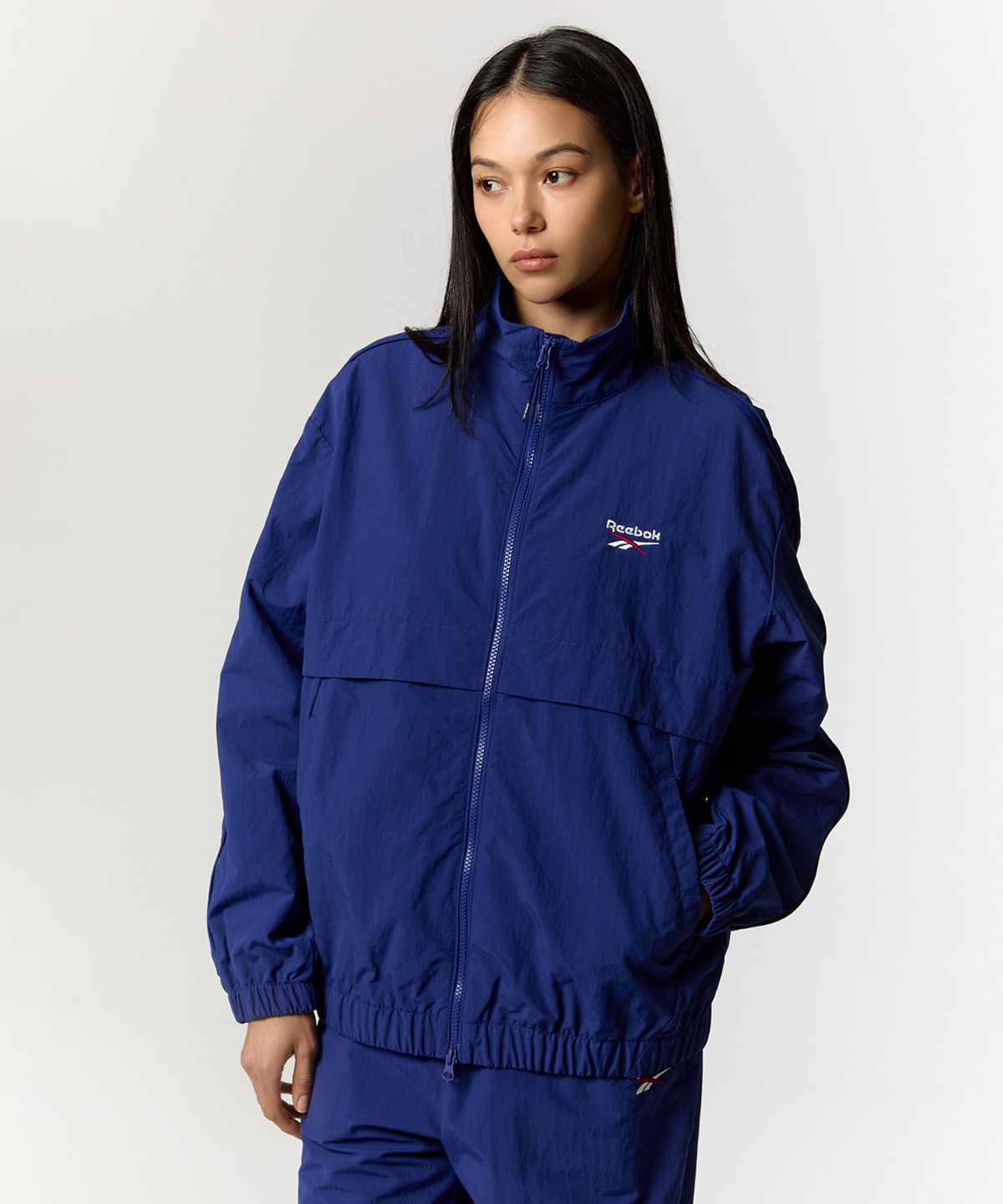 리복(REEBOK) 에센셜 웜업 윈드 브레이커 - 블루