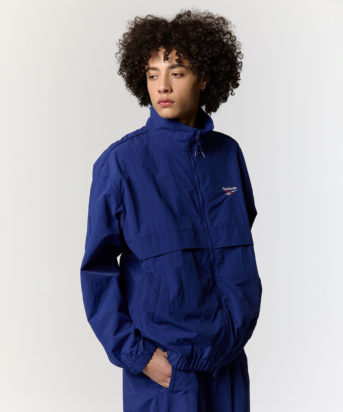 리복(REEBOK) 에센셜 웜업 윈드 브레이커 - 블루