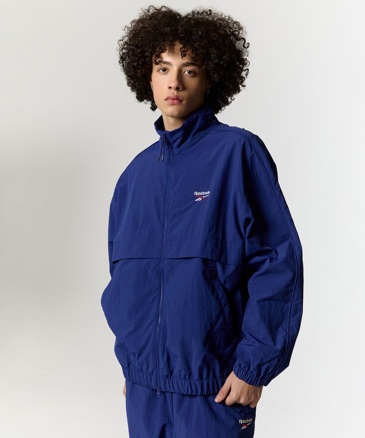 리복(REEBOK) 에센셜 웜업 윈드 브레이커 - 블루