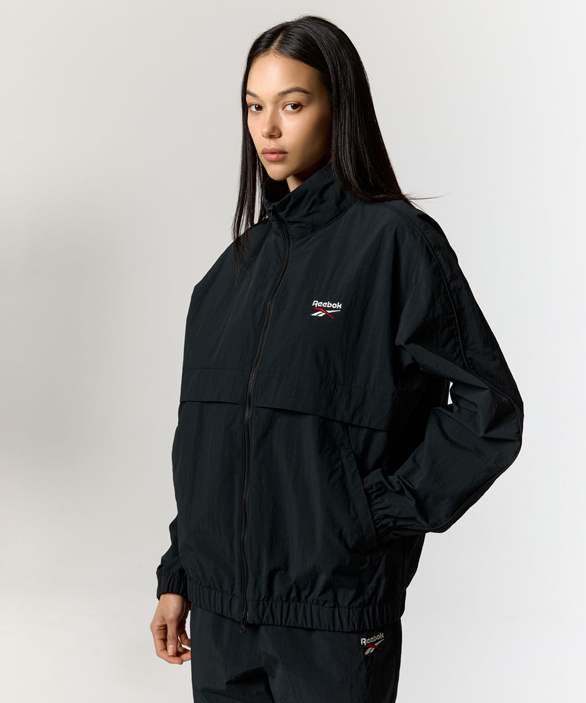 리복(REEBOK) 에센셜 웜업 윈드 브레이커 - 블랙
