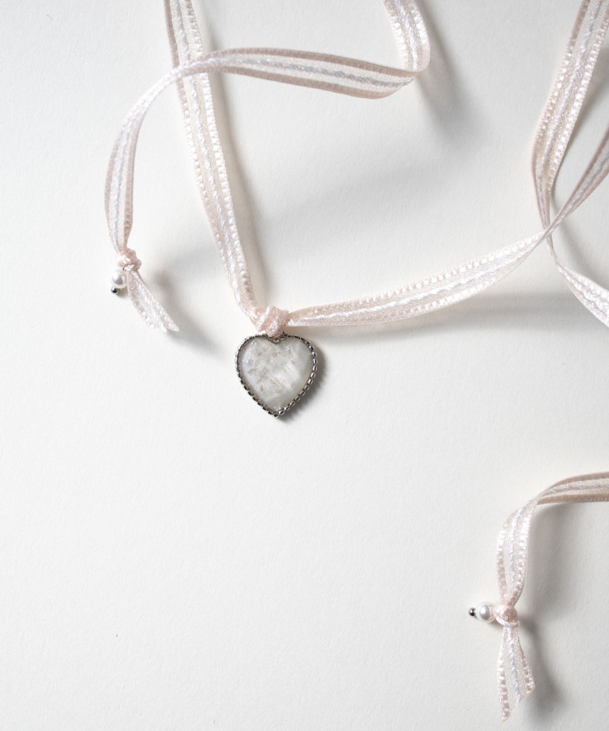 메리모티브(MERRYMOTIVE) Pearly heart and ribbon string necklace