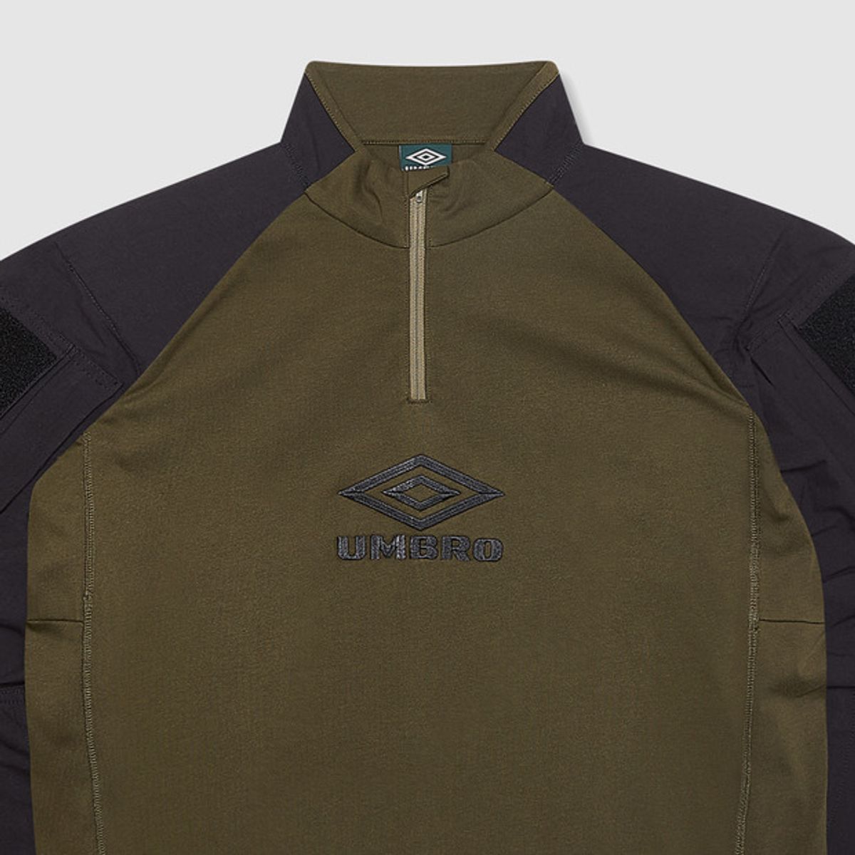 엄브로(UMBRO) [UMBRO X SLAM JAM] Tactical 반집업 긴팔 우븐탑 카키(UQ111CWT38)