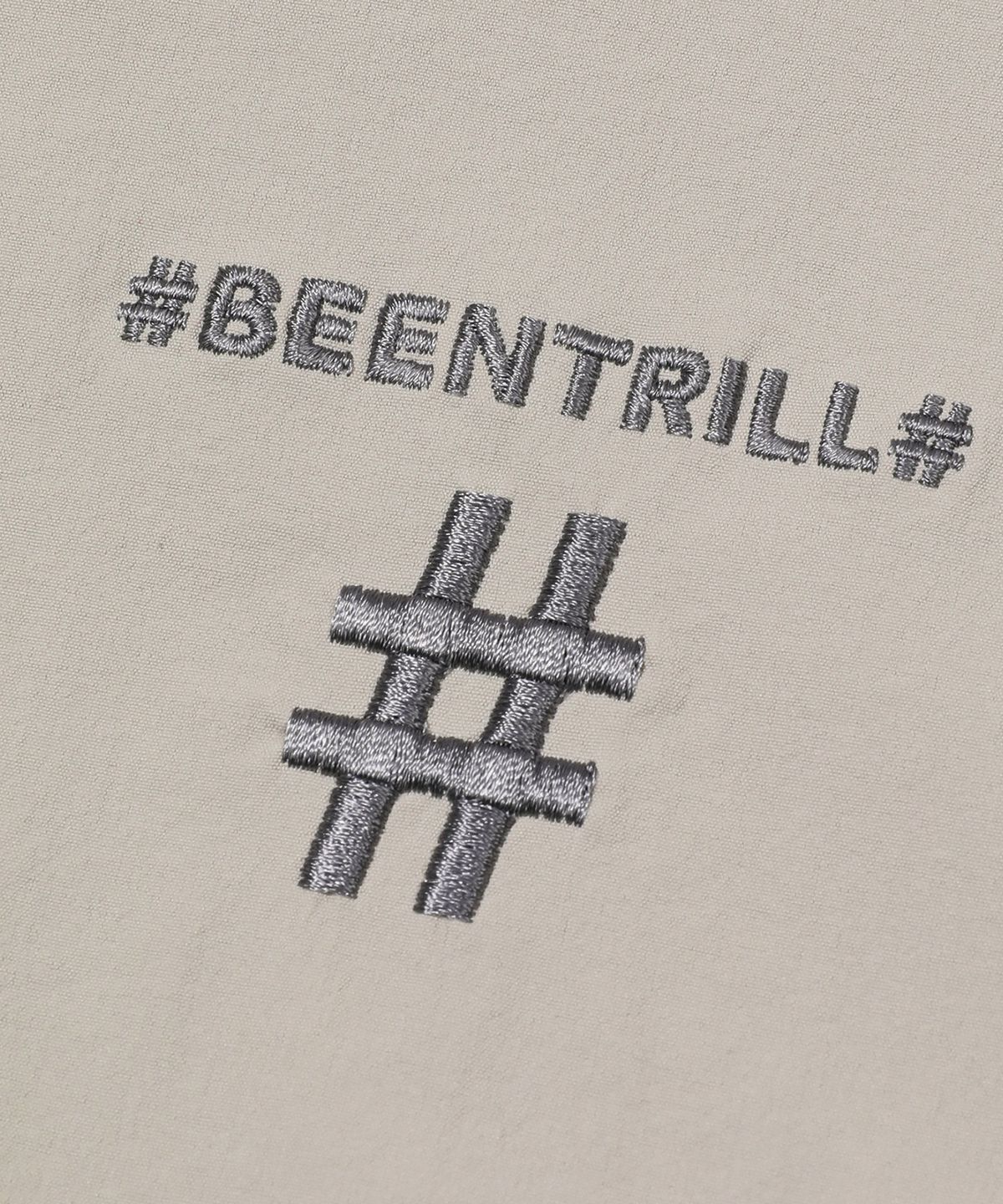 빈트릴(BEENTRILL) 스프레이 로고 우븐 아노락 점퍼(라이트 베이지)
