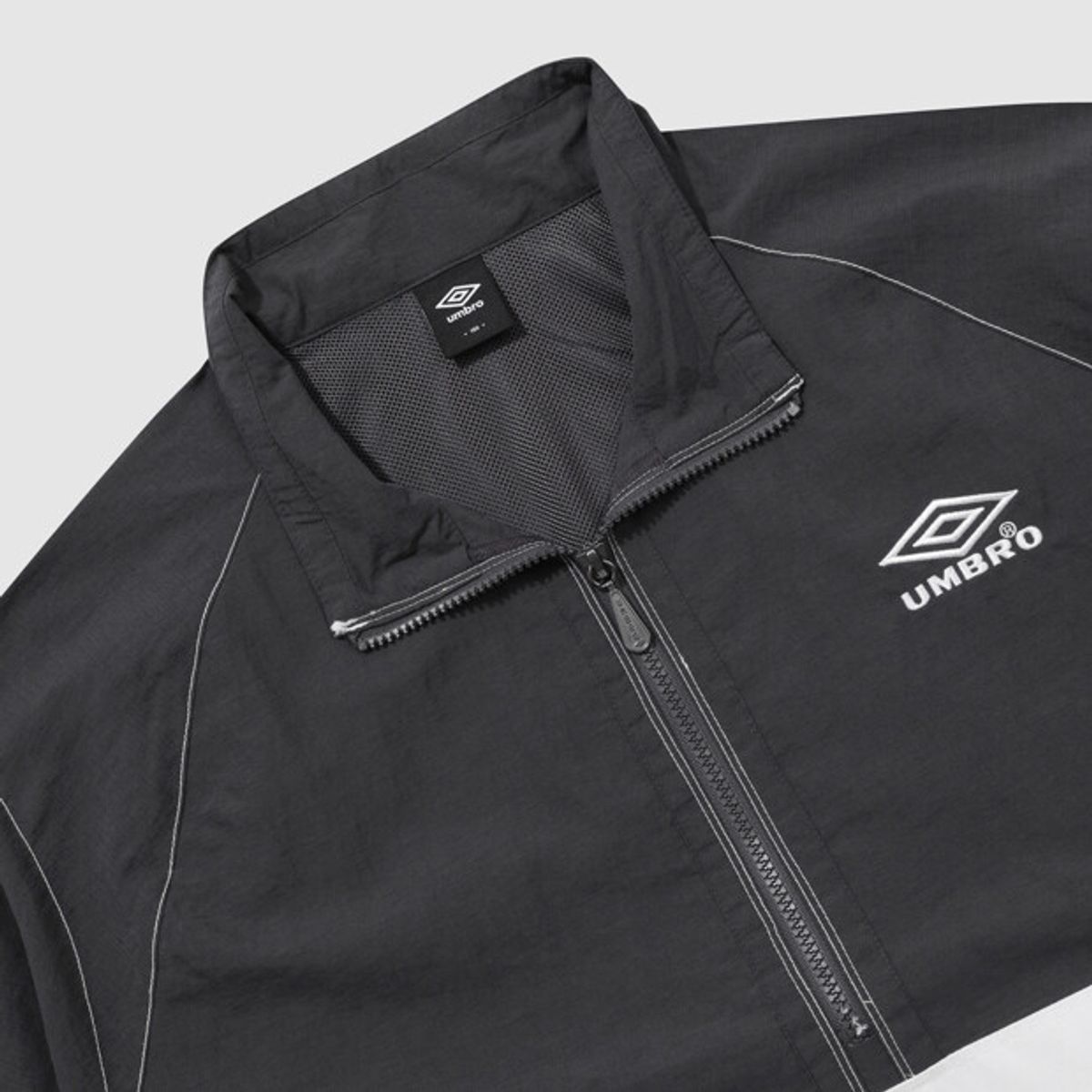 엄브로(UMBRO) 크리스피 타슬란 반팔 스탠넥 아노락 차콜(UQ223CWT59)