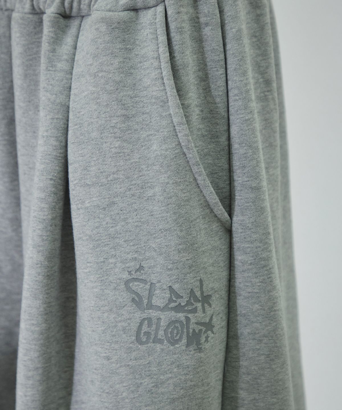 슬릭글로우(SLEEKGLOW) 로고 핀턱 와이드 커브드 스웨트 팬츠[그레이]