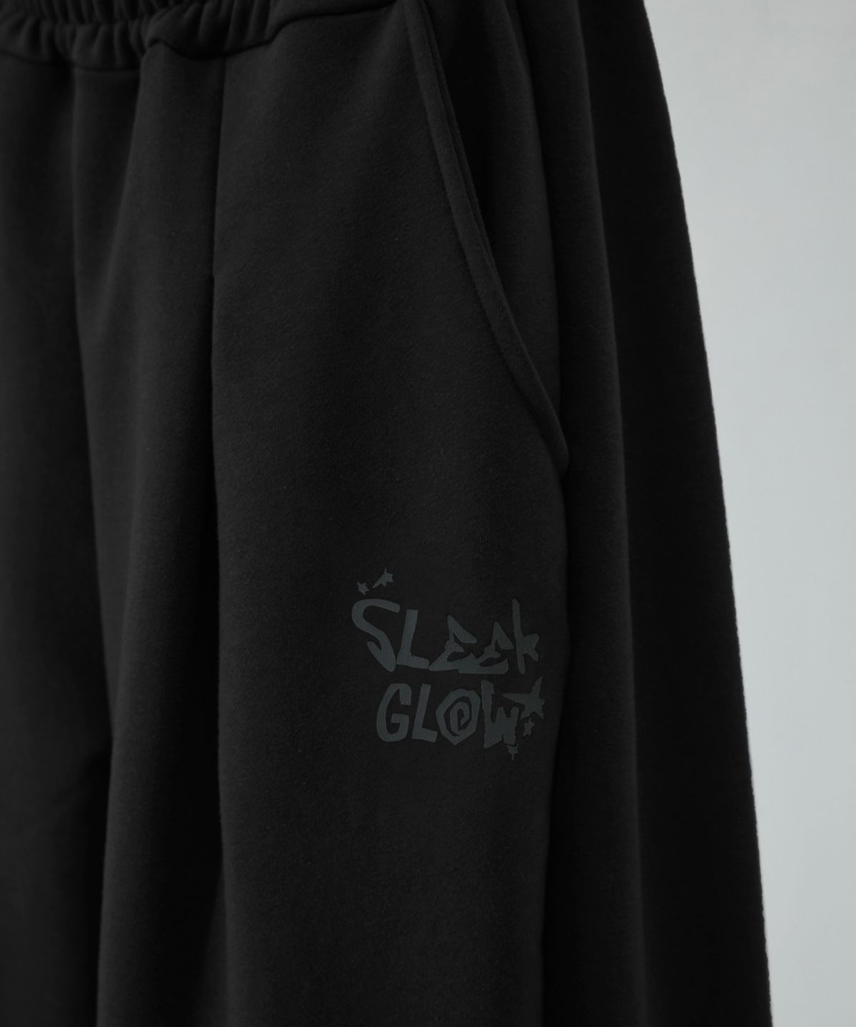 슬릭글로우(SLEEKGLOW) 로고 핀턱 와이드 커브드 스웨트 팬츠[블랙]