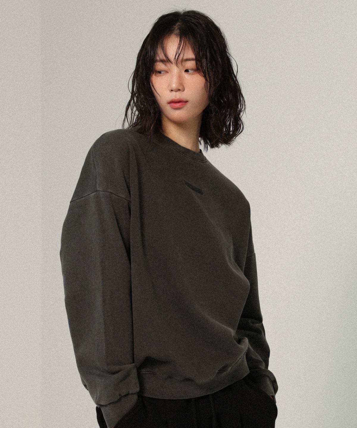 어센더(ASCENDER) 피그먼트 코어라벨 세미 오버핏 절개 맨투맨 [차콜]