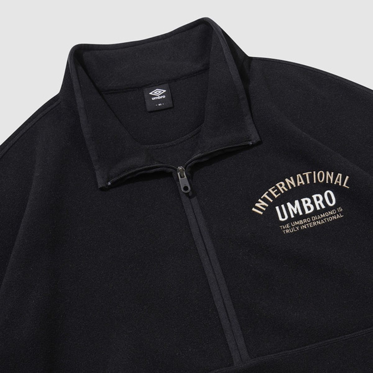 엄브로(UMBRO) 플러스플리스 레터링 하프집업 블랙 UQ423CFSN1