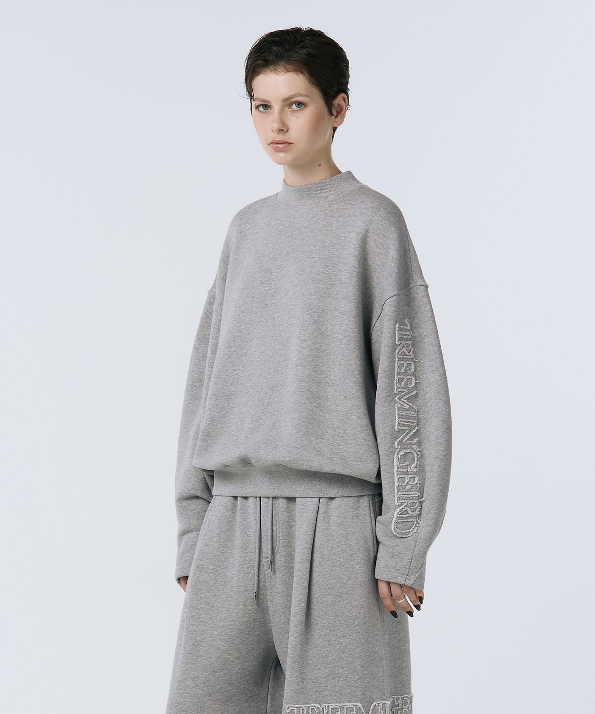 트리밍버드(TREEMINGBIRD) Cut-out Patch Mock Neck Sweatshirt [ Melange Gray ]