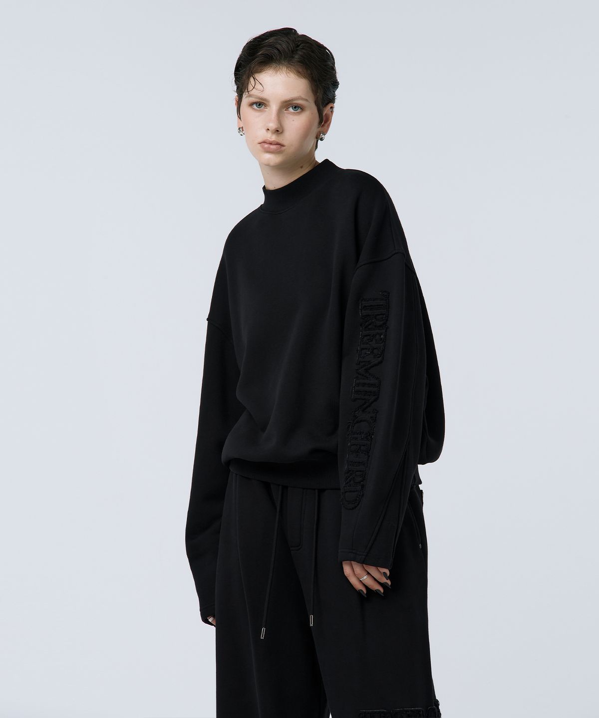 트리밍버드(TREEMINGBIRD) Cut-out Patch Mock Neck Sweatshirt [ Black ]