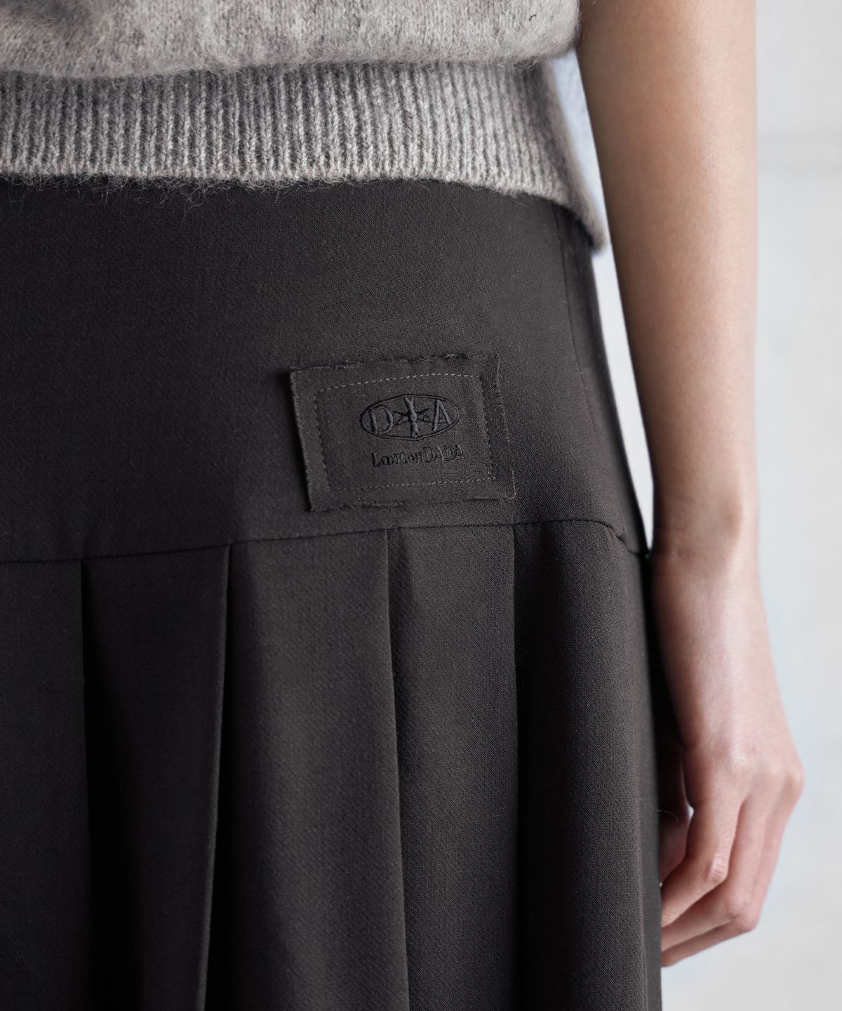 런던다다(LONDONDADA) LOGO PATCHED BUCKLE PLEATS SKIRT, GREY