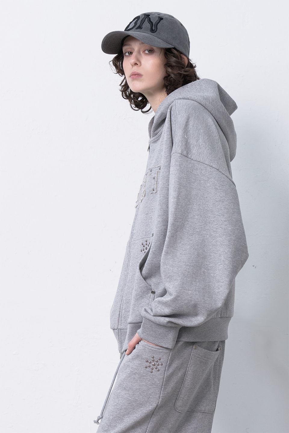 MUSINSA公式 | DEINET APPLIQUE STUD HOODED ZIP-UP IN MELANGE GREY