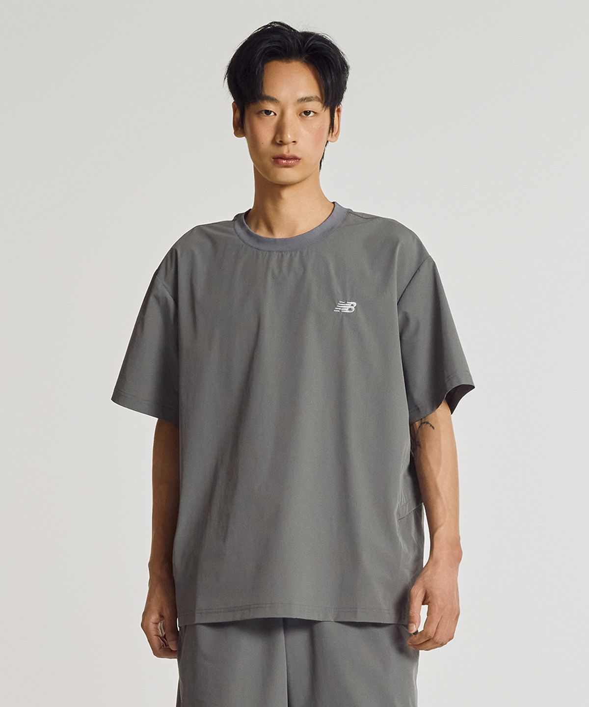 뉴발란스(NEW BALANCE) NBNEG31623 / UNI FROZEN ESSENTIAL 우븐 반팔티 (CHARCOAL)