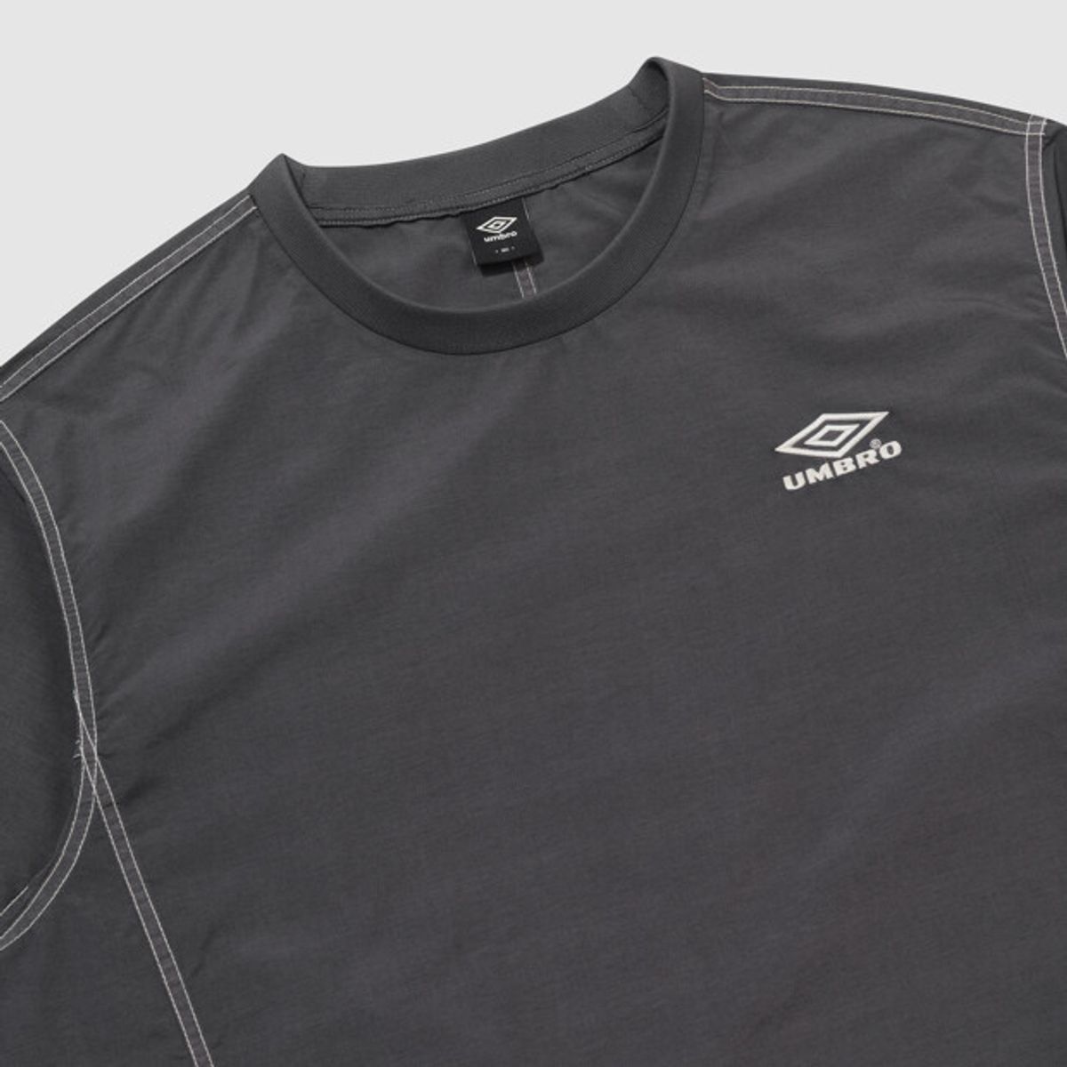 엄브로(UMBRO) 콘크리트 블룸 다잉 우븐 반팔 피스테 차콜 UR221CWT55