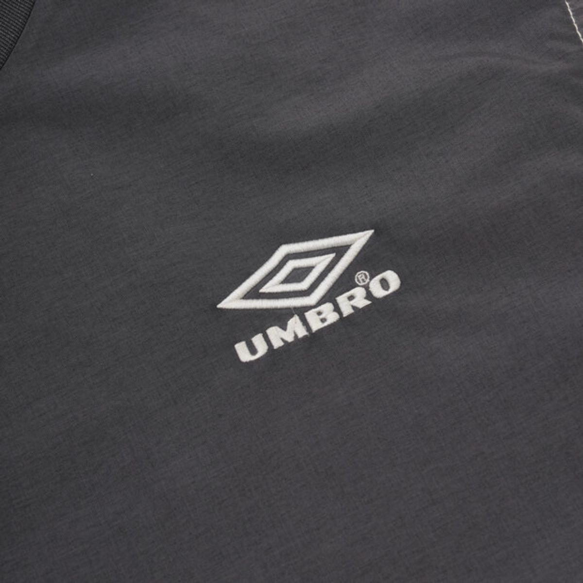 엄브로(UMBRO) 콘크리트 블룸 다잉 우븐 반팔 피스테 차콜 UR221CWT55