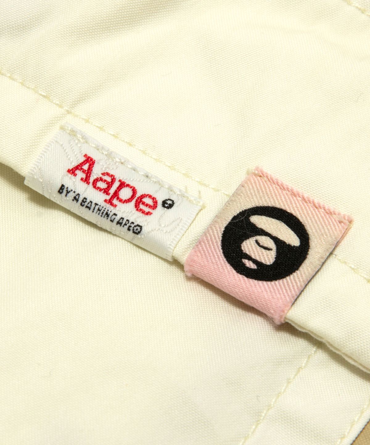 에이프(AAPE) AAPEUNVS 로고 쇼츠 아이보리 / AAPSPMD614XXQIVA